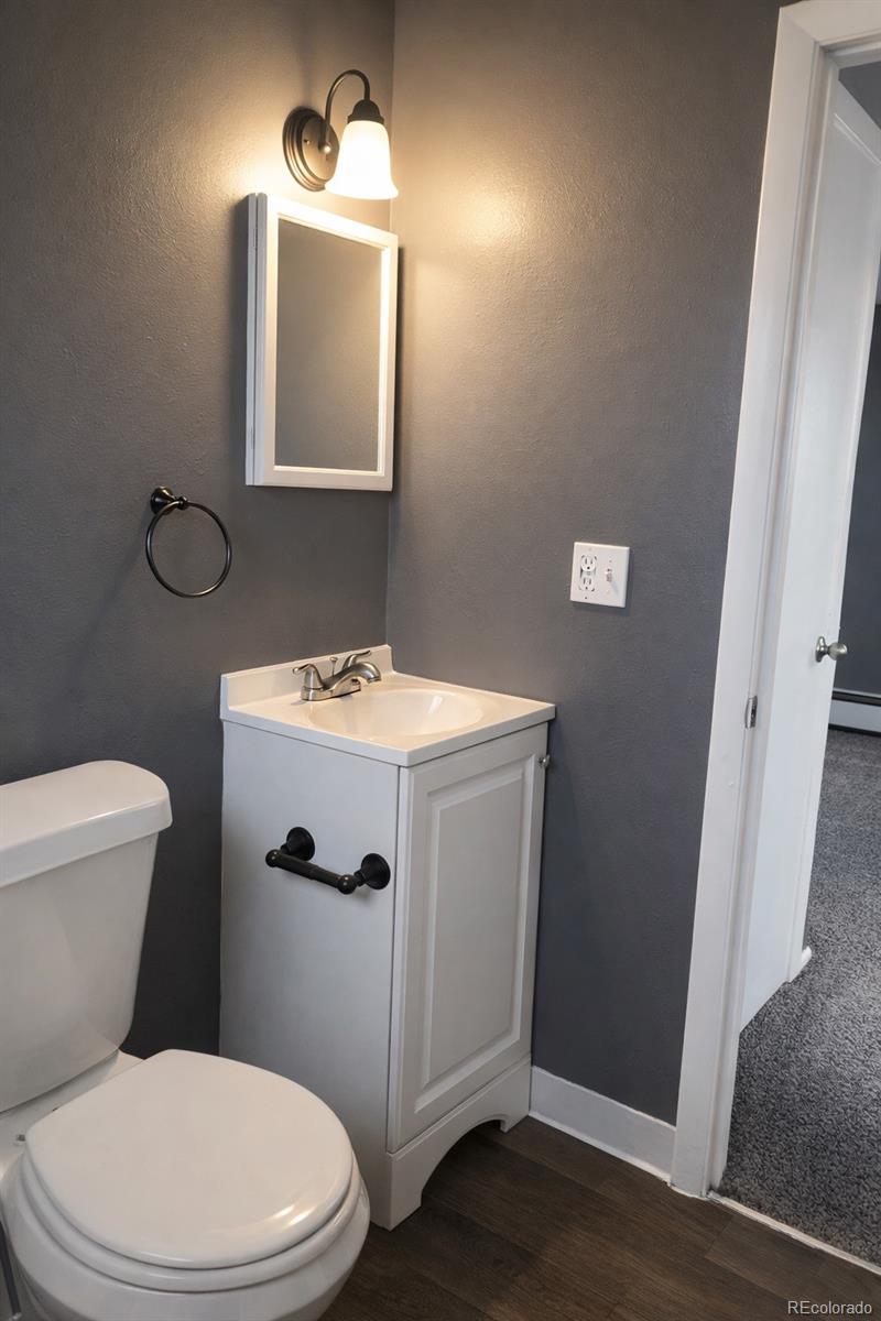 7155 Stuart Street Westminster, CO 80030 - Photo 5 of 11 a bathroom with a toilet a sink and mirror