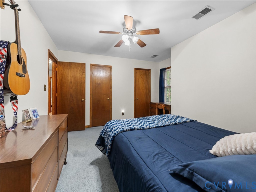 7706 Northern Dancer Court Midlothian, VA 23112 - Photo 26 of 40 a bedroom with a bed and a chandelier