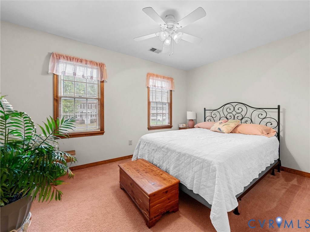 7706 Northern Dancer Court Midlothian, VA 23112 - Photo 27 of 40 a bedroom with a bed next to a window with potted plant