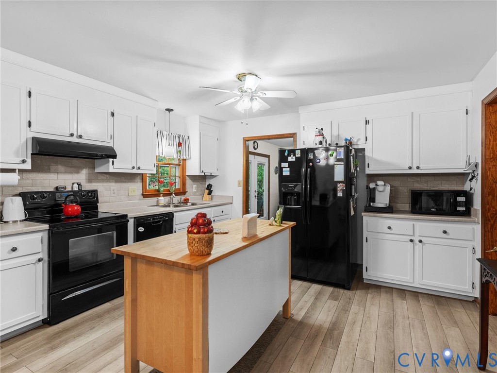 7706 Northern Dancer Court Midlothian, VA 23112 - Photo 10 of 40 a kitchen with stainless steel appliances kitchen island granite countertop a refrigerator a stove top oven a sink dishwasher and white cabinets with wooden floor