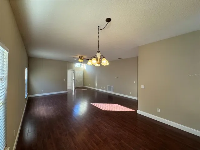 a view of a room with wooden floor and chandelier