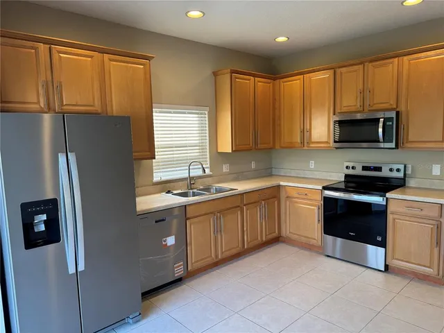 a kitchen with granite countertop a refrigerator and a sink