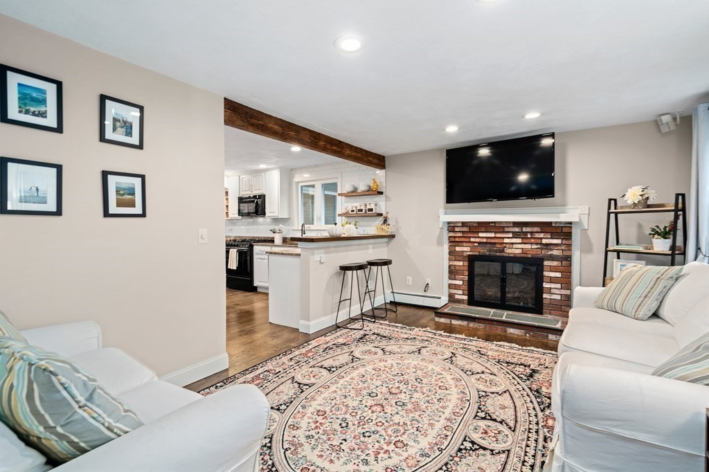 4 Robert Street Walpole, MA 02081 - Photo 7 of 37 a living room with furniture a flat screen tv and a fireplace