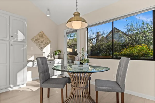 a dining room with furniture wooden floor and a floor to ceiling window