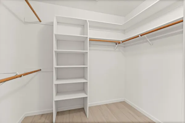 a view of walk in closet with empty racks