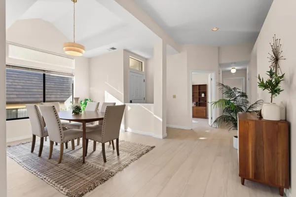 a dining room with furniture potted plants and wooden floor