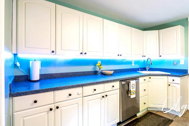 a kitchen with stainless steel appliances white cabinets and a window
