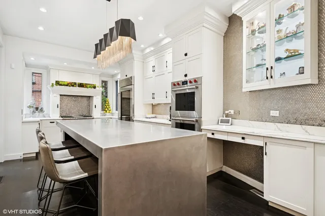 a kitchen with a sink a stove and chairs with cabinets