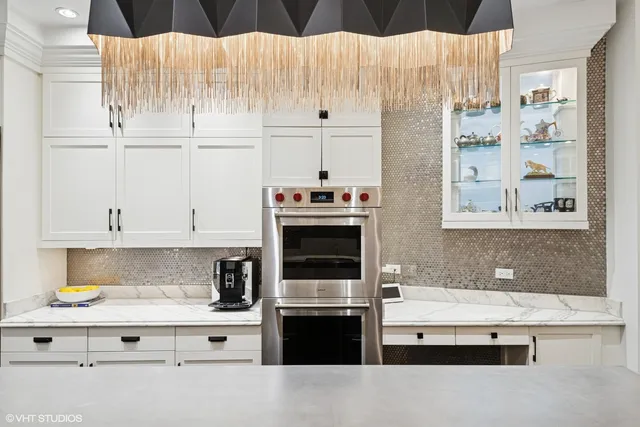 a kitchen with granite countertop white cabinets and stainless steel appliances