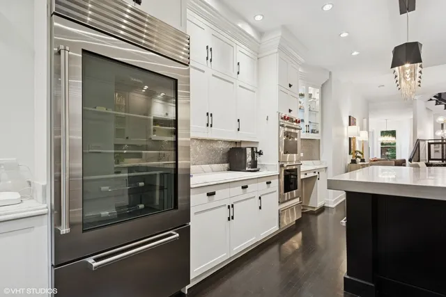 a kitchen with white cabinets and stainless steel appliances