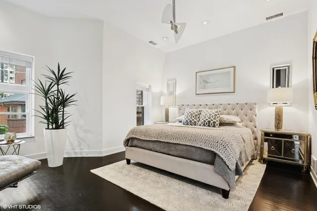 a spacious bedroom with a bed a couch and potted plant on the table