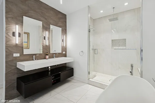 a en suite bathroom with a double vanity sink a mirror and a shower