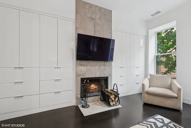 a living room with furniture a flat screen tv and a fireplace