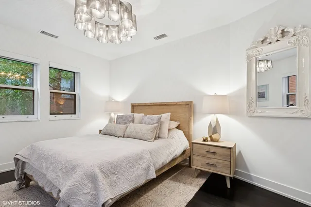 a bedroom with a bed and a chandelier