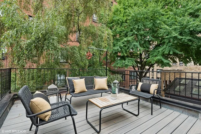 a roof deck with couches and wooden fence