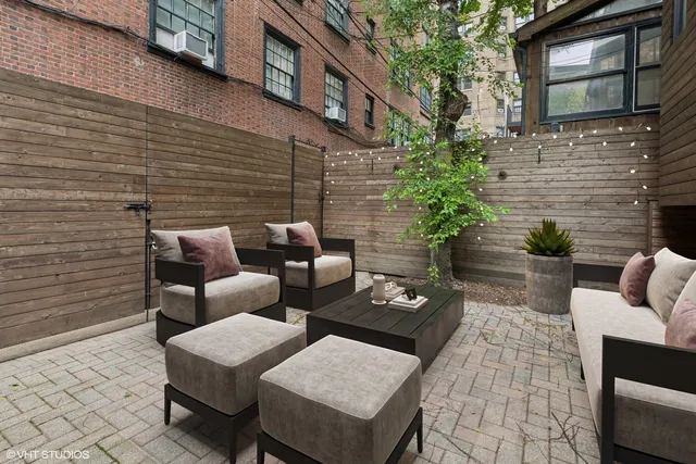 a view of a patio with couches table and chairs and potted plants