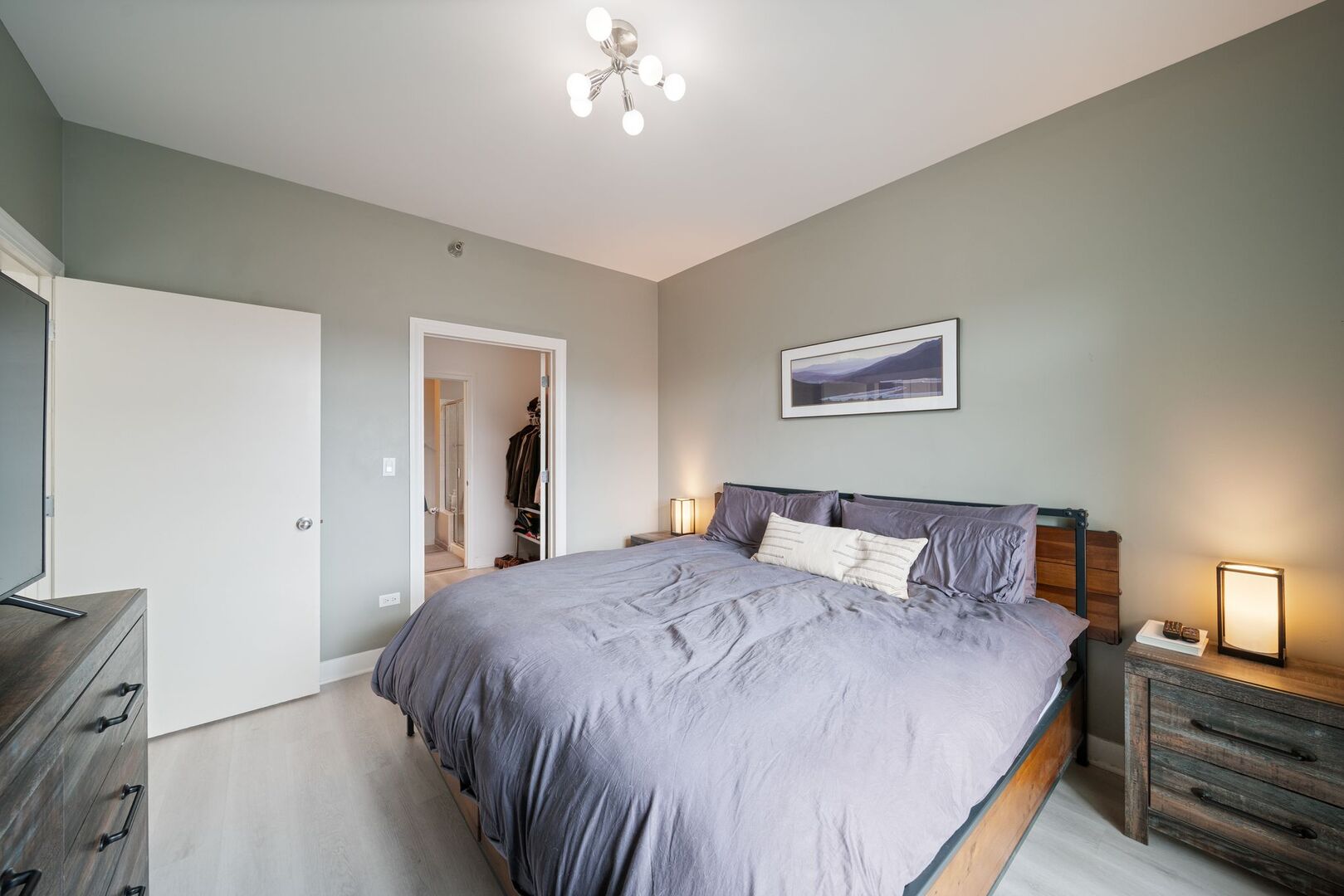 225 South Sangamon Street, Unit 308 Chicago, IL 60607 - Photo 14 of 34 a bedroom with a large bed and a chandelier
