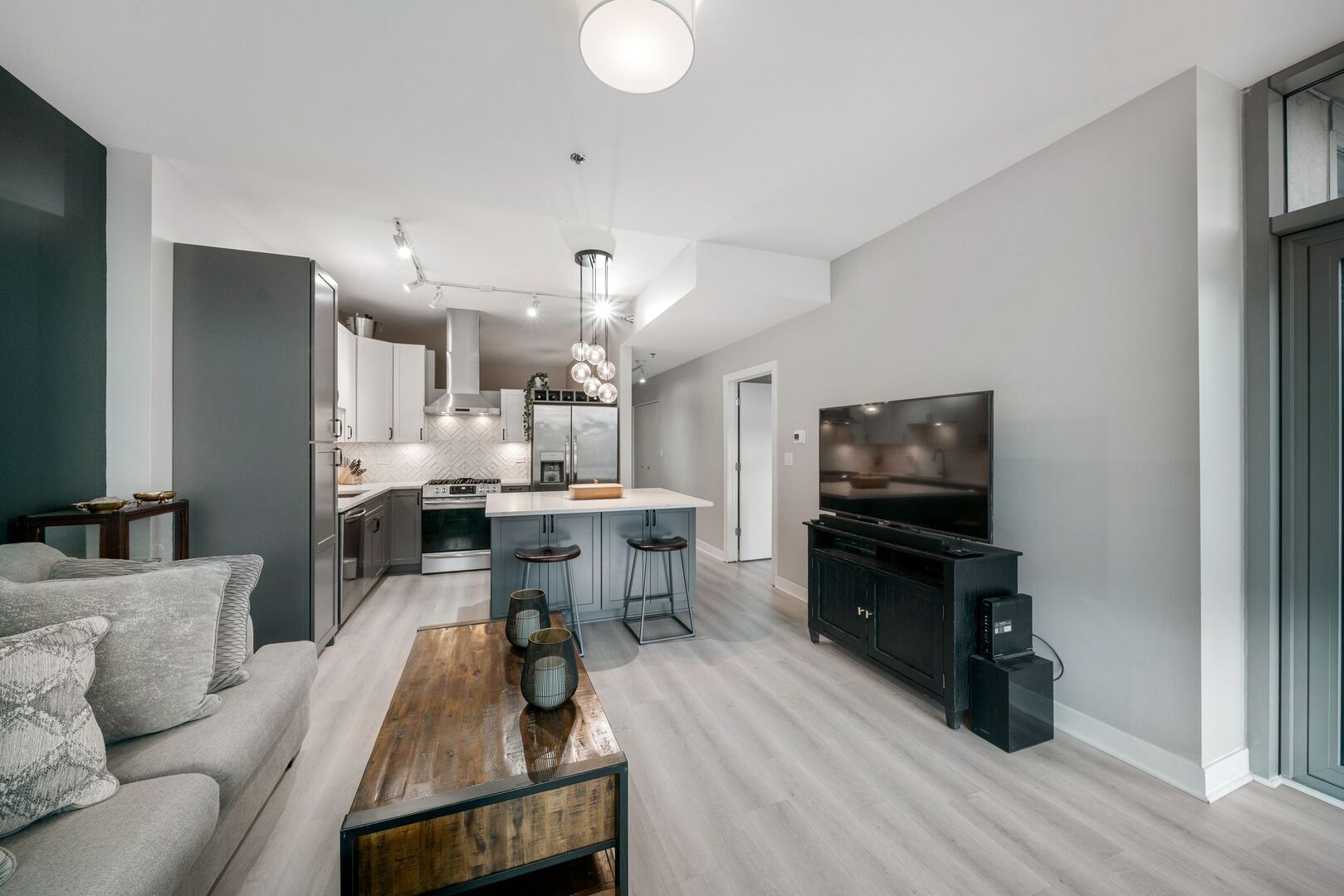 225 South Sangamon Street, Unit 308 Chicago, IL 60607 - Photo 6 of 34 a living room with furniture a flat screen tv and kitchen view