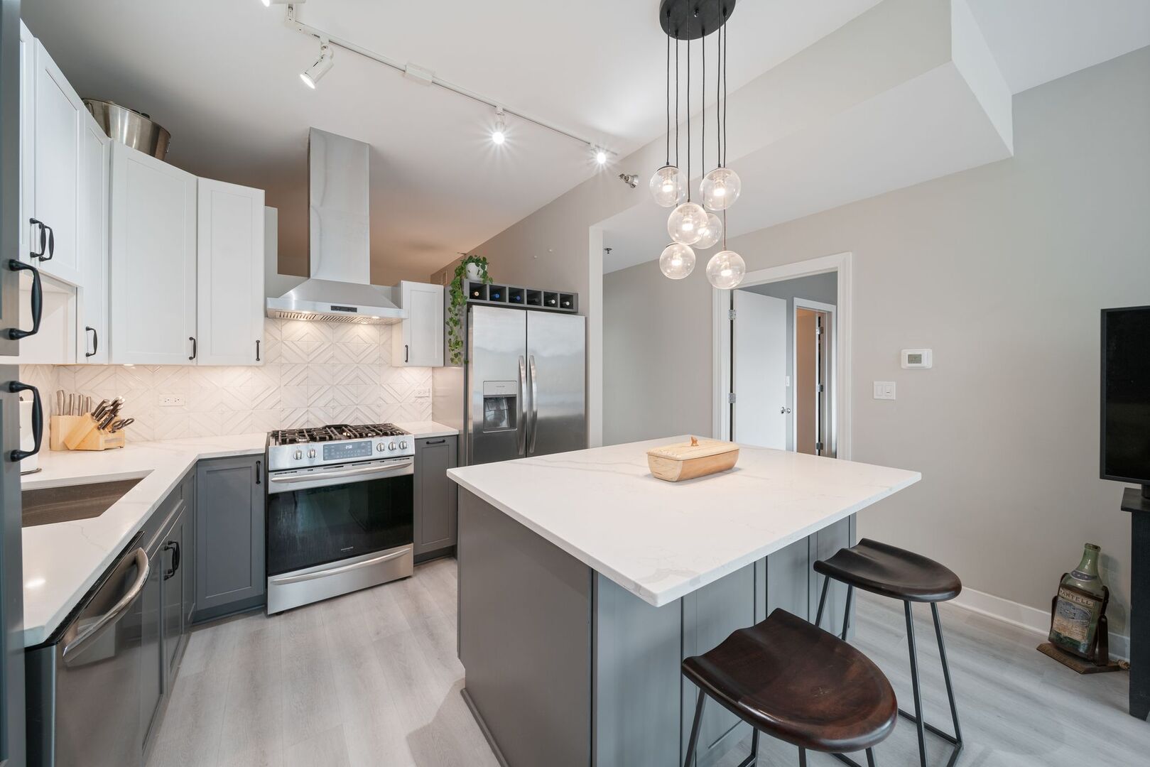 225 South Sangamon Street, Unit 308 Chicago, IL 60607 - Photo 10 of 34 a kitchen with kitchen island a stove a chandelier and a refrigerator