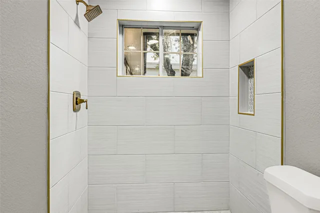 a bathroom with a toilet and a shower