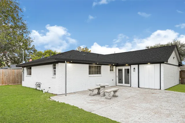 a backyard of a house with table and chairs