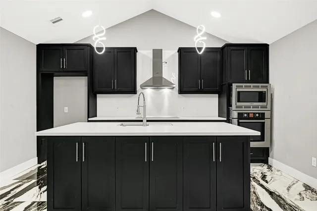 a kitchen with stainless steel appliances a sink and cabinets