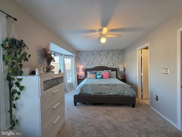 a bedroom with a bed and a potted plant