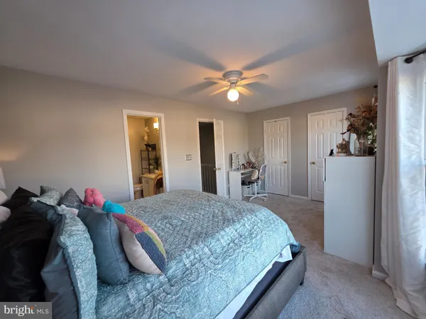 a spacious bedroom with a bed and a chandelier