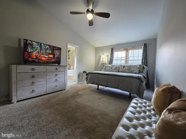 a spacious bedroom with a bed and a flat screen tv