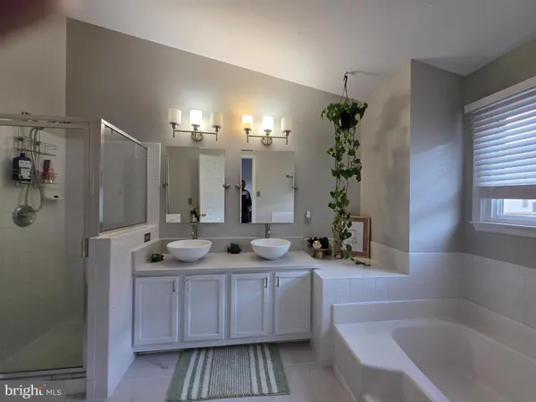 a bathroom with a tub sink and mirror