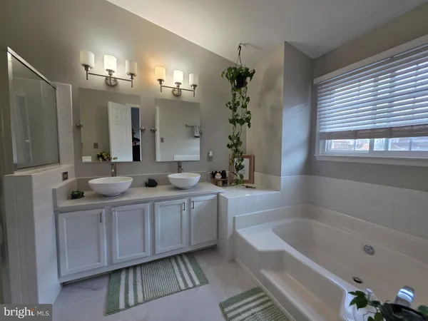 a bathroom with a tub a sink and mirror