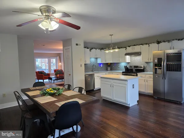 a kitchen with a table chairs appliances and cabinets