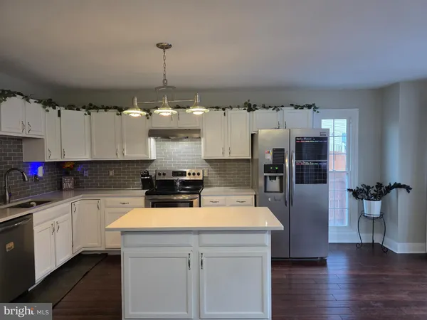 a kitchen with a refrigerator a stove top oven a sink and cabinets