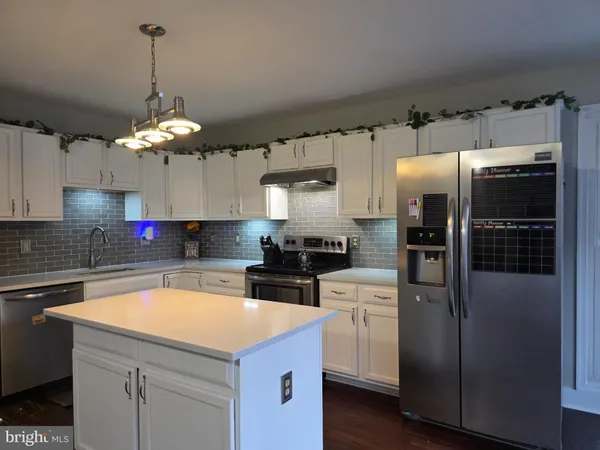 a kitchen that has a lot of cabinets and stainless steel appliances