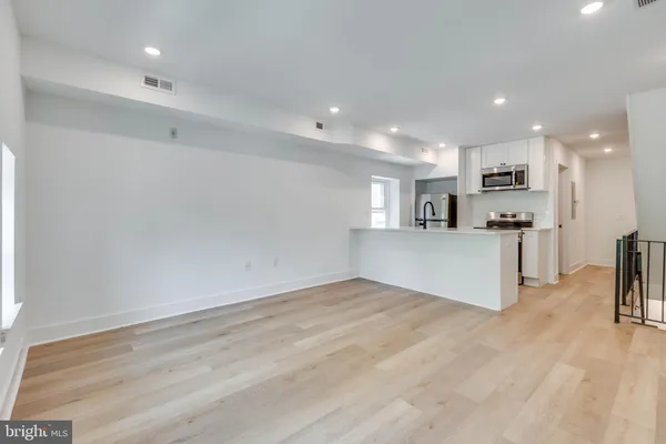 a view of kitchen with kitchen island white cabinets and refrigerator