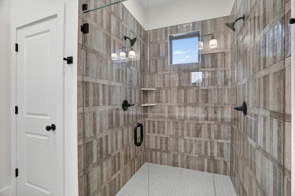 225 Kilkenny Road Poolville, TX 76487 - Photo 19 of 36 Spacious walk-in shower featuring glass enclosure, patterned tile walls, and a square window