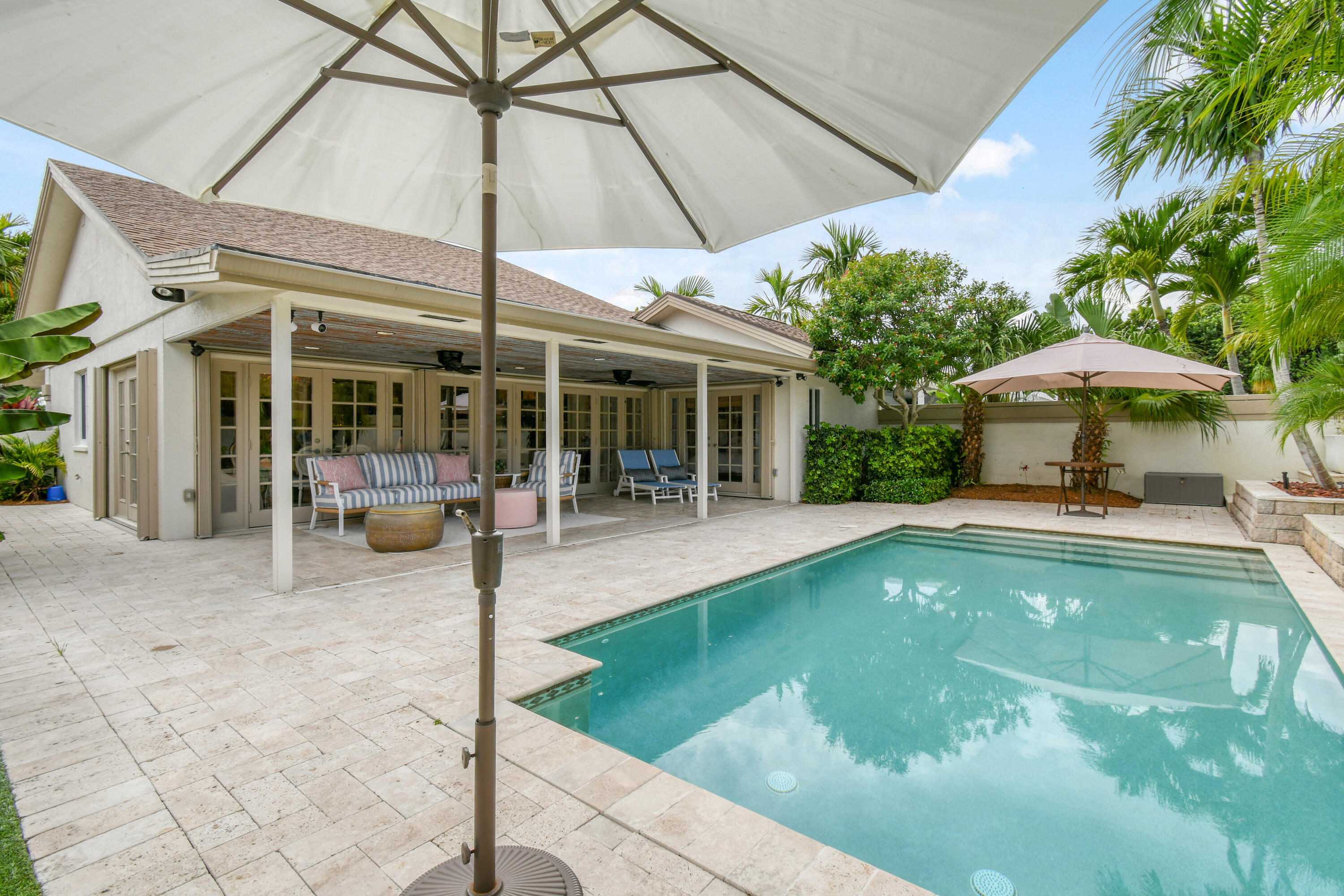 127 Dunes Edge Road Jupiter, FL 33477 - Photo 11 of 58 a view of a patio with a table and chairs under an umbrella