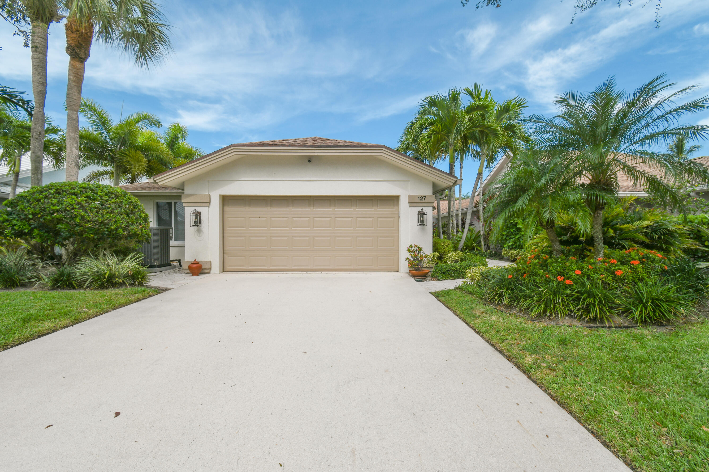 127 Dunes Edge Road Jupiter, FL 33477 - Photo 6 of 58 a front view of a house with a yard and garage