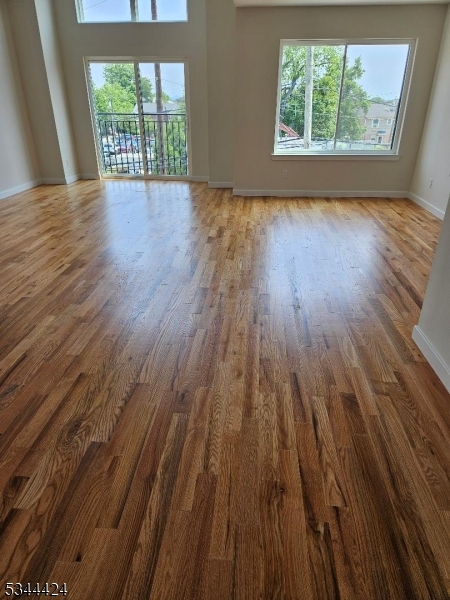 685 Bergen Street Newark, NJ 07108 - Photo 4 of 12 an empty room with wooden floor and windows