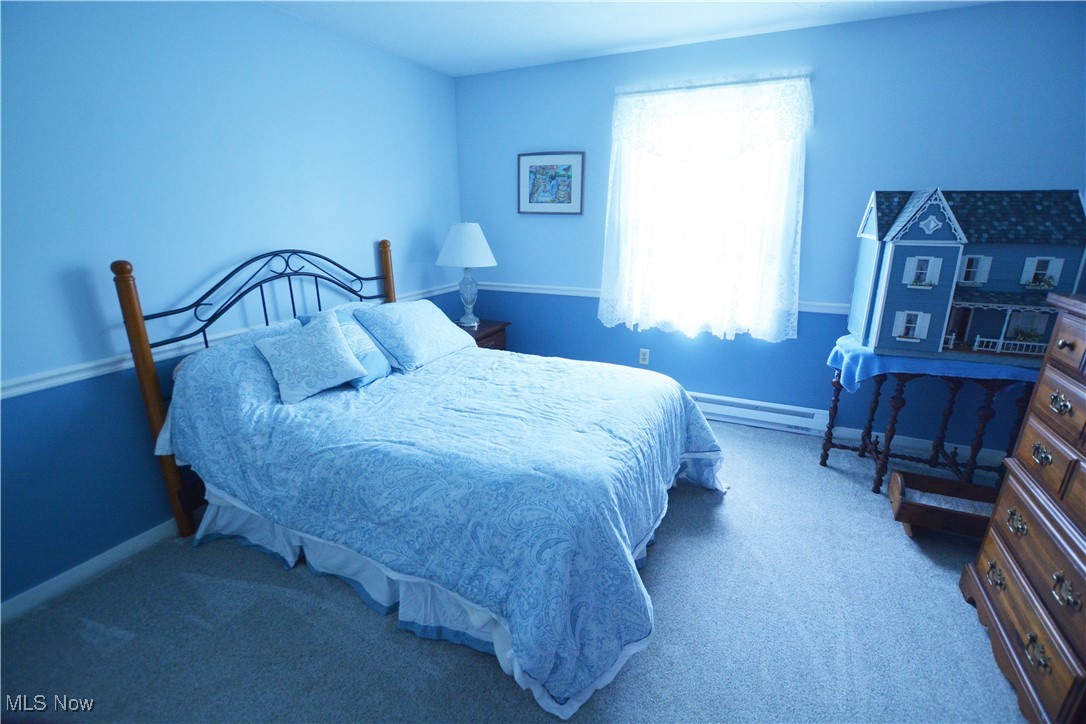 16140 Thompson Road Thompson, OH 44086 - Photo 41 of 50 Carpeted bedroom featuring a baseboard heating unit, multiple windows, and baseboards