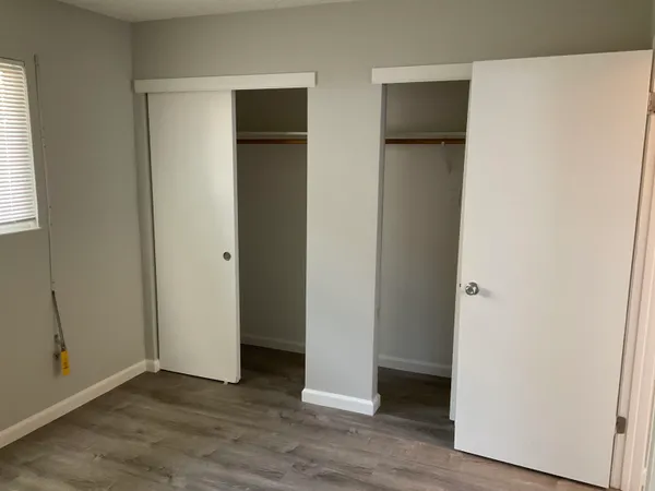 an empty room with wooden floor and closet
