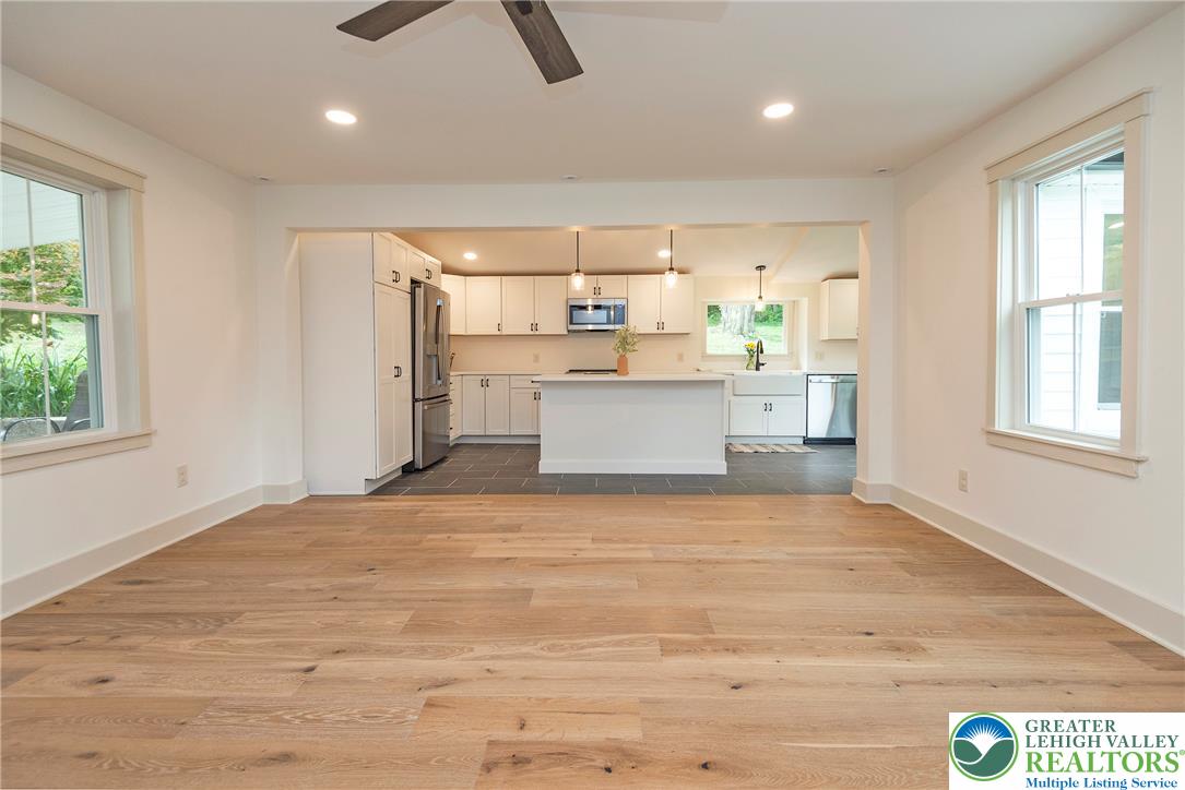 72 Allegheny Road Mount Bethel, PA 18343 - Photo 7 of 72 Bright, airy living space features lustrous wood floors flowing into a modern, open-concept kitchen.
