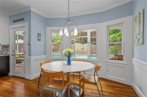 a dining room with furniture a chandelier and wooden floor