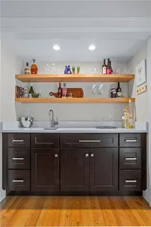a open kitchen with a fireplace and wooden floor