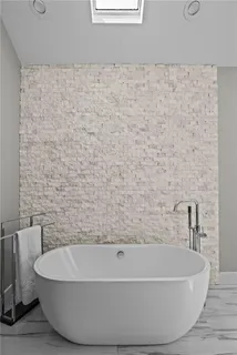 a bathroom with a granite countertop sink a toilet a mirror and bathtub