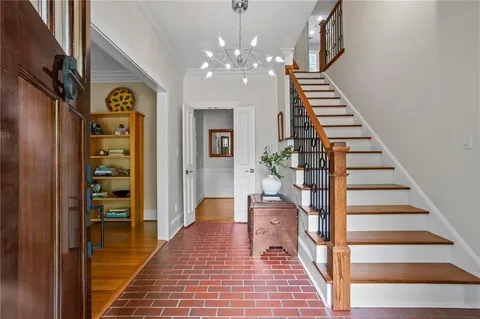 a view of a hallway with wooden floor and staircase