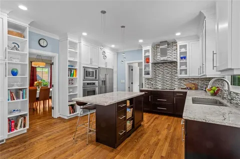 a kitchen with stainless steel appliances granite countertop wooden cabinets and sink