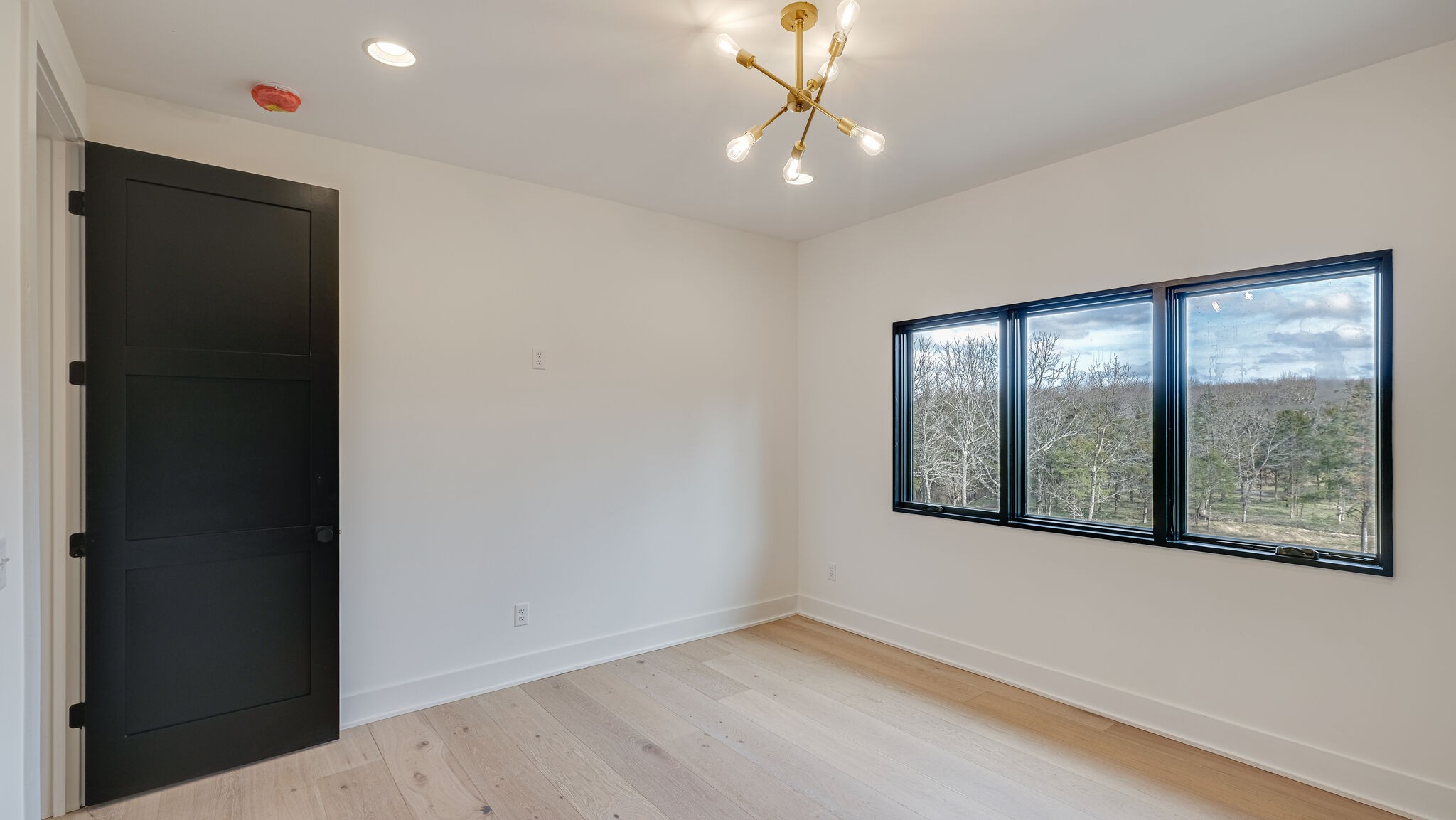 8564 Taliaferro Road Eagleville, TN 37060 - Photo 34 of 49 an empty room with wooden floor and windows