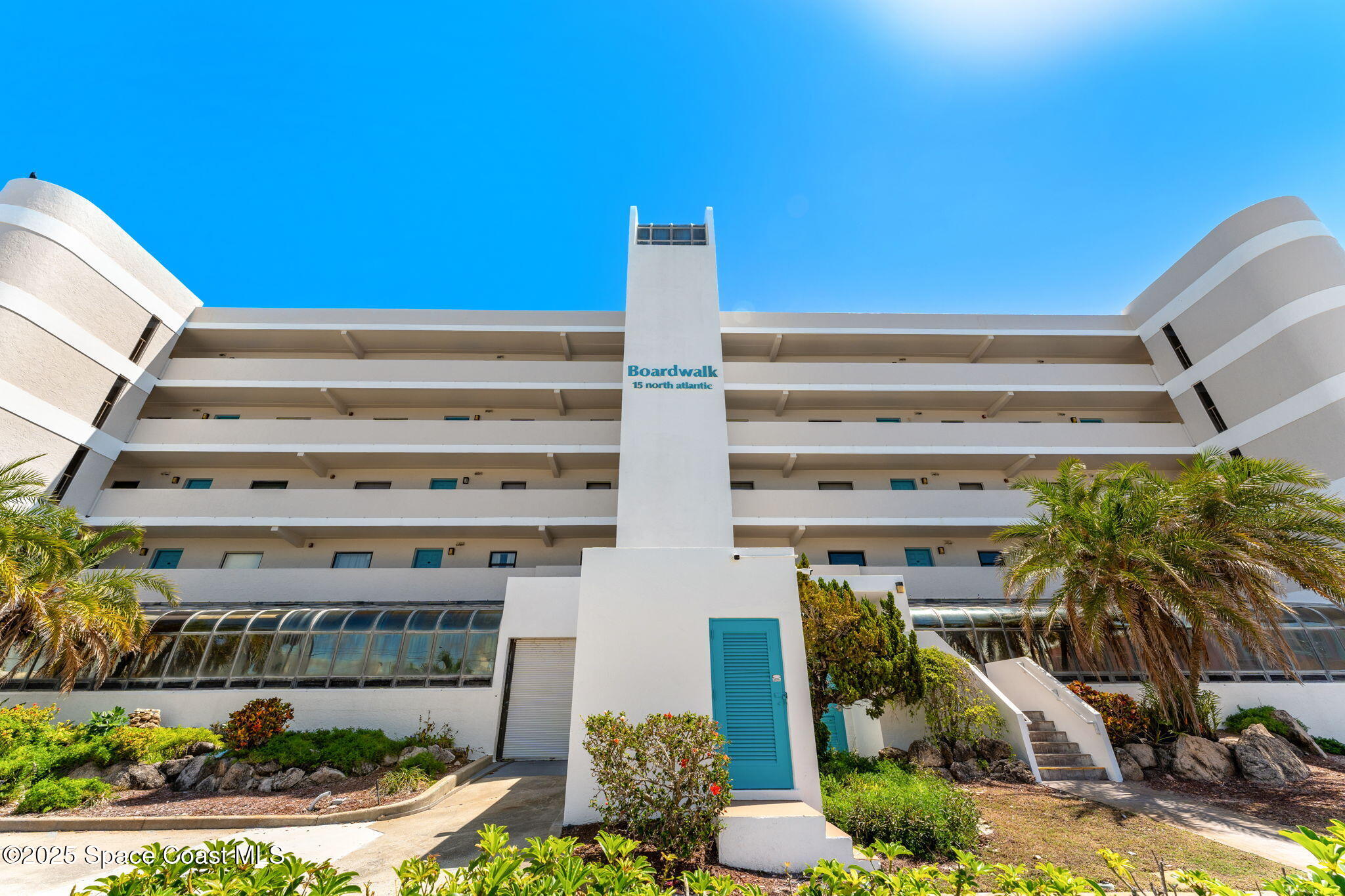 15 North Atlantic Avenue, Unit 401 Cocoa Beach, FL 32931 - Photo 1 of 33 a front view of a building with glass windows and plants