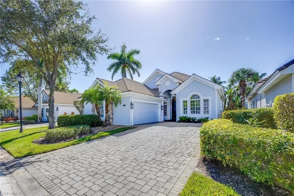 a front view of a house with a yard and potted plants